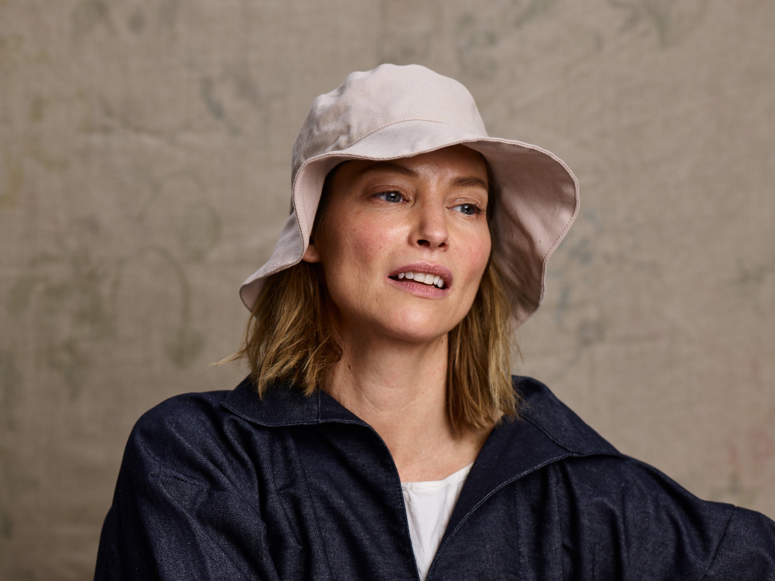 Woman wearing Carrier Company V-Neck Smock in Denim and Cotton sun Hat
