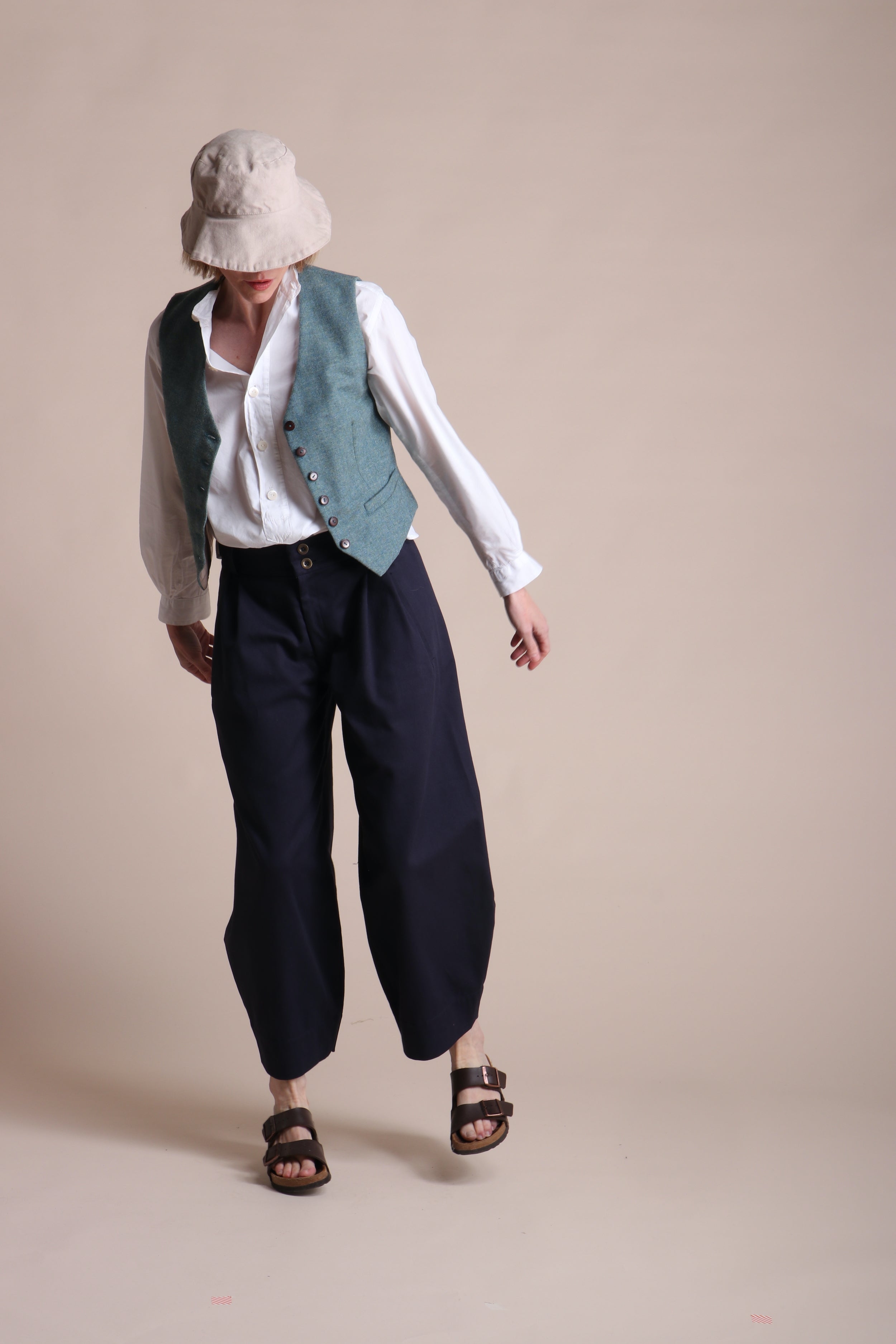 Woman wearing Carrier Company Dutch trouser In Navy Cotton Drill and Lightweight Collaless Work Shirt, Women's Wool Waistcoat and Cotton Sun Hat